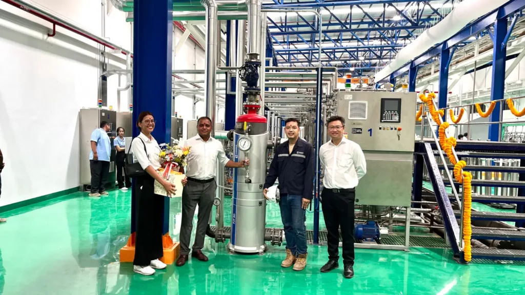 Forbes Marshall Thailand team members at a greenfield textile plant standing next to a condensate recovery pump